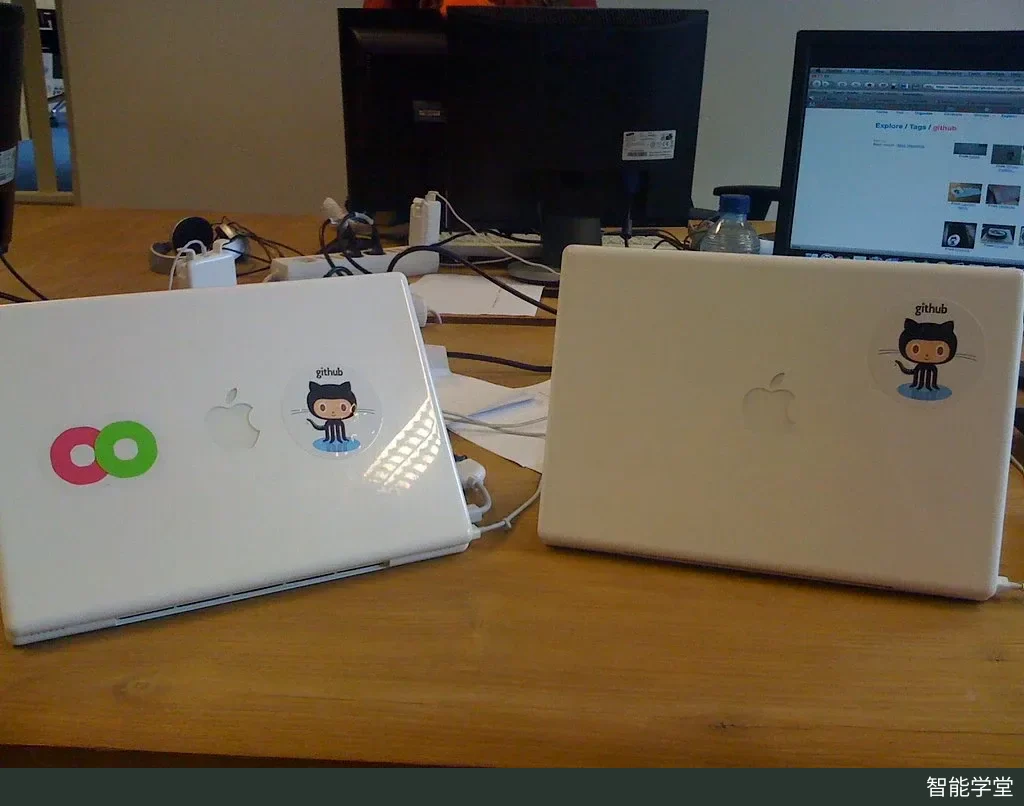 多台 MacBook 笔记本电脑的机身上带有 GitHub 吉祥物章鱼猫 Octocat 的图案